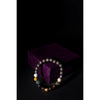 Beaded bracelet on a dark background with a purple cushion