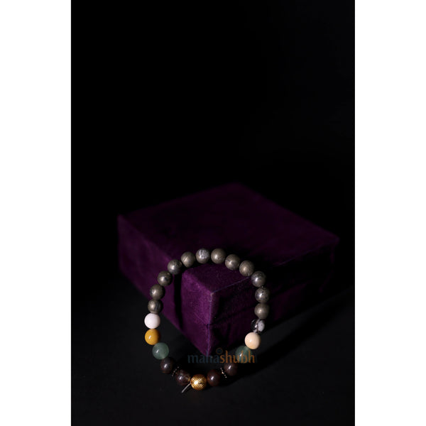 Beaded bracelet on a dark background with a purple cushion