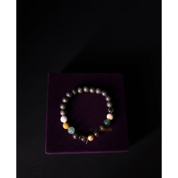Multicolored beaded bracelet on a purple velvet box with 'maharishi' branding.