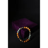 Multicolored beaded bracelet on a dark background with a purple box.