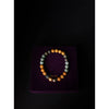 Multicolored beaded bracelet on a purple cushion with 'Shubh' branding.