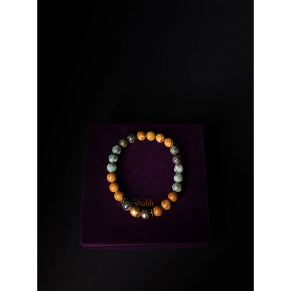 Multicolored beaded bracelet on a purple cushion with 'Shubh' branding.