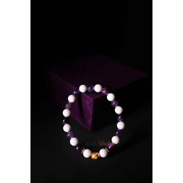 Bracelet with white, purple, and gold beads on a dark background