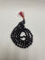 A traditional 108-bead Black Rudraksha Mala with a red silk tassel