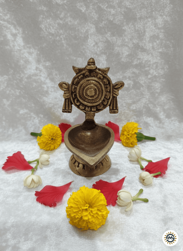 Decorative brass lamp with flowers on a textured gray background