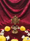 Bronze lamp with decorative flowers on a red fabric background