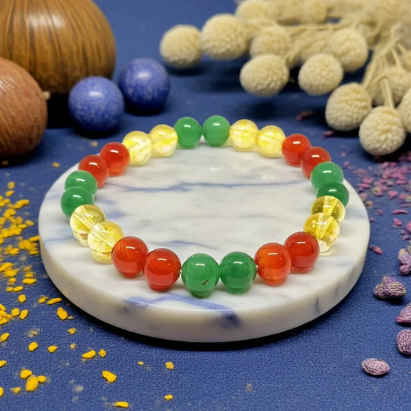 Colorful beaded bracelet on a marble coaster with decorative items around