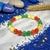 Colorful beaded bracelet on a white fabric background with blue beads and stones.