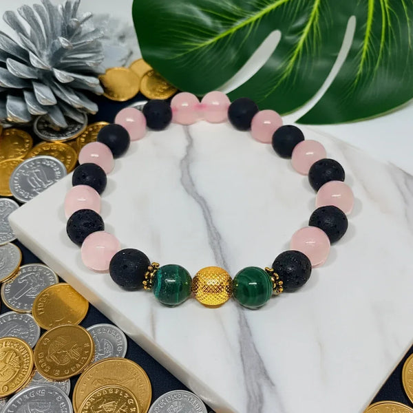 Colorful beaded bracelet on a marble surface with coins and leaves in the background