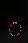 Depression Healing Bracelet featuring smooth, round beads of purple Amethyst, lilac Lepidolite, and deep black Tourmaline, arranged in a calming sequence on an elastic cord