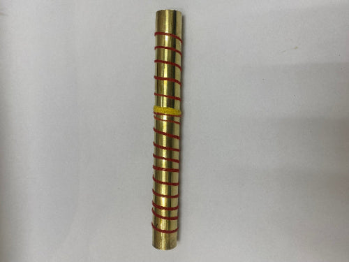 Brass cylindrical object with red bands on a white background
