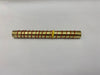 A gold-colored metal rod with red and yellow wires spiraling around it, placed on a white surface.