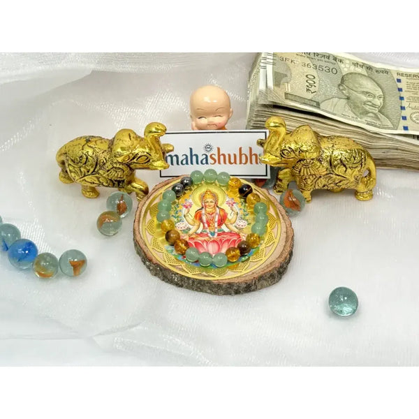 Decorative item with a statue, gold lions, and money on a white surface