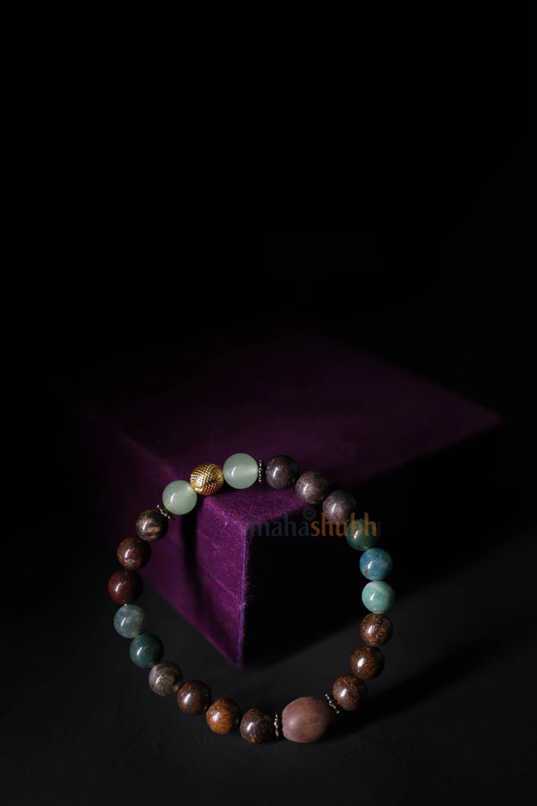 Multicolored beaded bracelet on a dark background with a purple cube