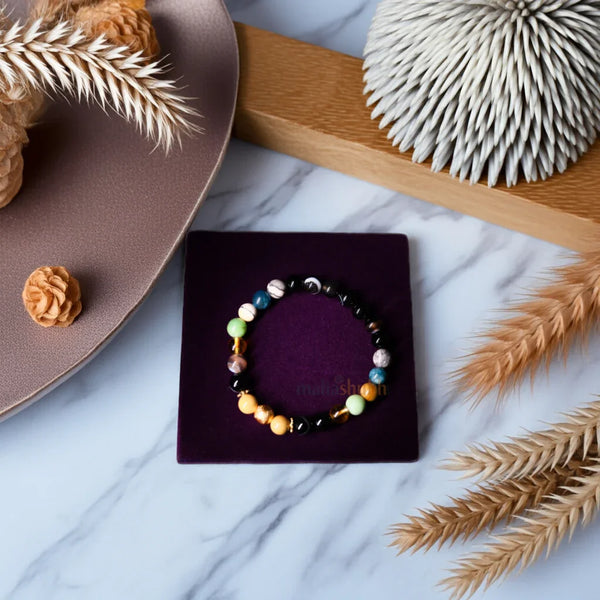 Colorful beaded bracelet on a purple box with decorative elements on a marble surface