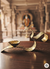 Brass OM diya lamp on wooden table inside traditional Indian temple with blurred deity statue in background