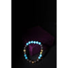 Multicolored beaded bracelet on a dark background with a purple fabric