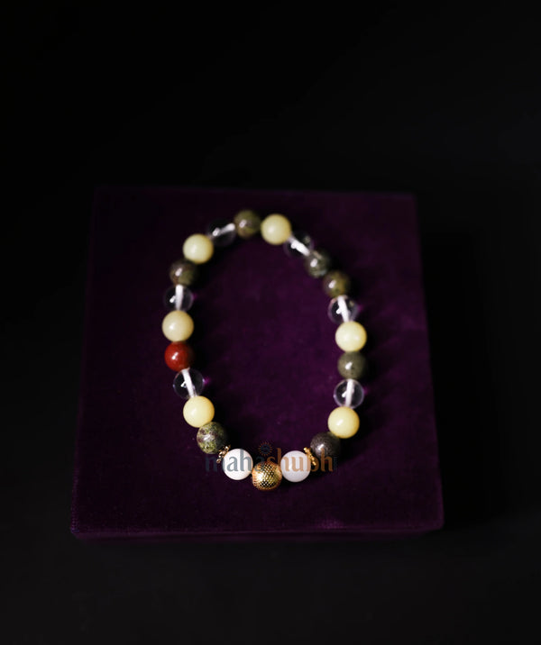 Beaded bracelet on a purple cushion with a black background