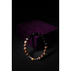 Beaded bracelet on a dark surface with a purple fabric background
