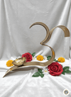 Brass Om diya lamp on white fabric with red roses, marigolds, and white flowers, Maha Shubh decor