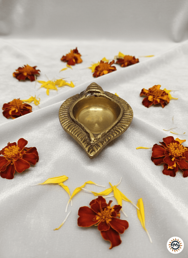 Brass diya lamp on white silk cloth decorated with marigold flowers and petals, Maha Shubh
