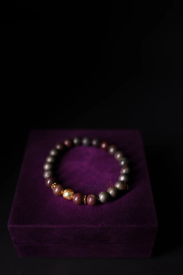 Multicolored beaded bracelet on a purple velvet box against a black background