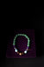 Beaded bracelet on a purple stand with a dark background