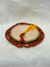 Close-up view of 5 Mukhi Rudraksha beads showing the natural texture, deep grooves, and five lines (mukhas) signifying the Five Faces of Shiva
