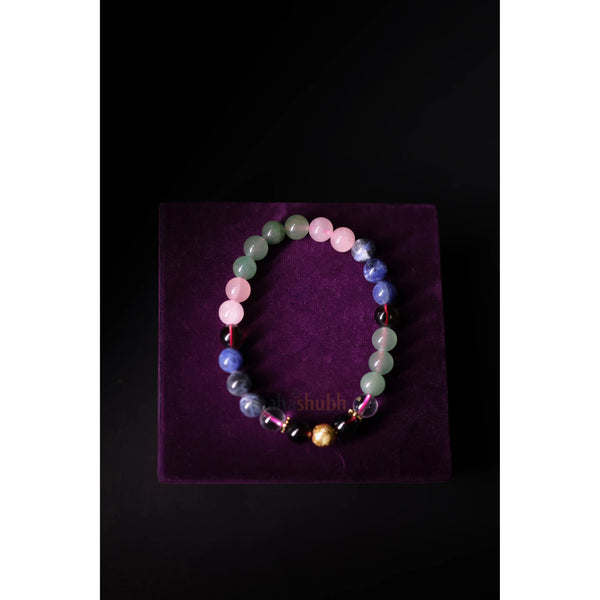 Multicolored beaded bracelet on a purple velvet surface with 'Shubh' branding.