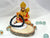 A black banded bracelet displayed next to a figure of a deity, possibly indicating the spiritual or protective properties associated with the product.