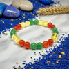 Colorful beaded bracelet on a white fabric background with blue beads and stones.