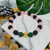 Colorful beaded bracelet on a marble surface with coins and leaves in the background