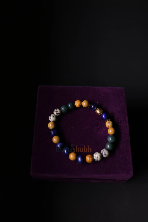 A hand-strung emotional support bracelet with natural gemstones in shades of purple and black, styled on a person's wrist against a soft, peaceful background