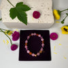 Bracelet on a black box with flowers and leaves around on a light background