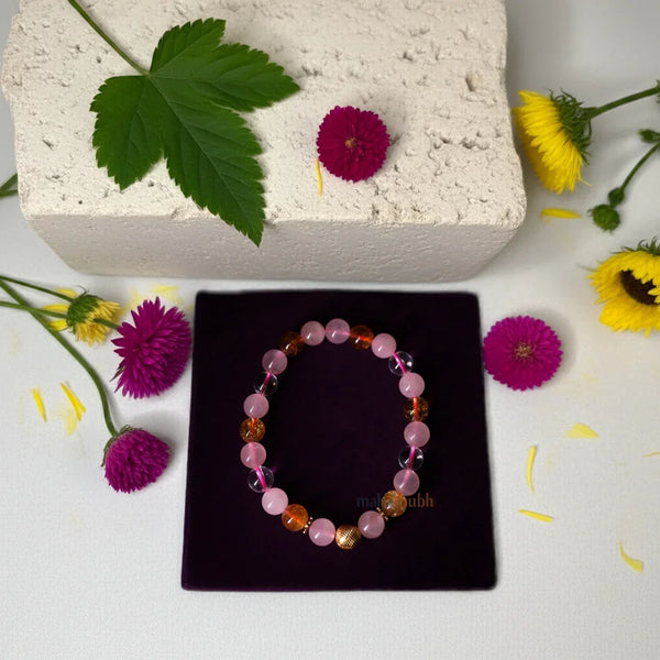 Bracelet on a black box with flowers and leaves around on a light background