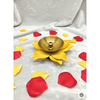 A vibrant yellow flower-shaped brass diya with a glossy finish