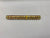 A gold-colored metal rod with red and yellow wires spiraling around it, placed on a white surface.