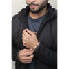 Man wearing a black jacket and blue shirt, holding a bracelet with beads.