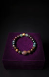 Multicolored beaded bracelet on a purple cushion with a dark background