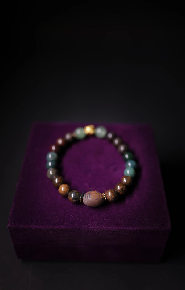 Multicolored beaded bracelet on a purple cushion with a dark background