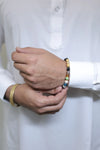 Close-up of two hands wearing colorful beaded bracelets on a white background