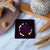Colorful beaded bracelet on a purple box with decorative elements on a marble surface