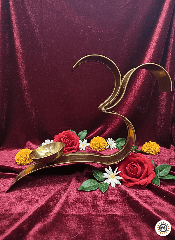 Brass Om symbol diya decor with red, yellow marigold, and white flowers on maroon velvet