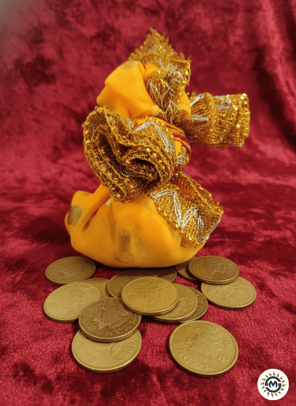 Yellow fabric pouch with gold trim on a red background with gold coins.