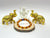 A golden Rudraksha Citrine bracelet displayed with intricately designed elephant figures and a series of round beads on a wooden platform, with a small plaque reading 'mahashubh.com'.