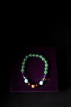 Beaded bracelet on a purple stand with a dark background