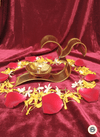 Golden Om diya lamp on red velvet with arranged red rose, yellow and white flower petals