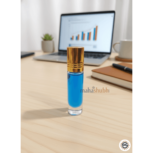 Blue rollerball bottle with gold cap on a desk next to a laptop and notebook.