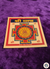 Decorative card with a geometric design on a purple fabric background